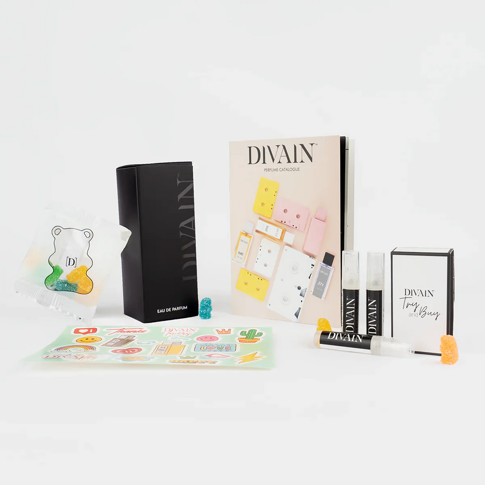 Opened divain package containing divain-015 perfume, stickers, and gummy candies
